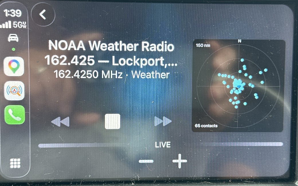 CarPlay showing NOAA Weather Radio playing live with a 150 nm aircraft radar